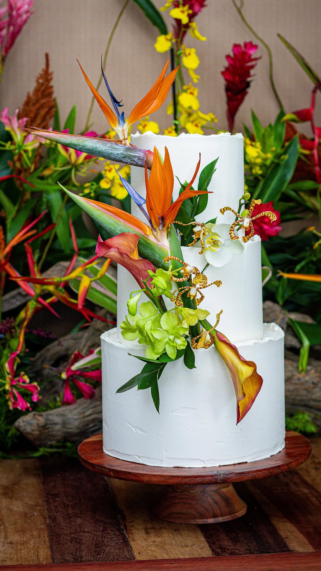 Bolo de casamento branco de três andares decorado com flores tropicais
