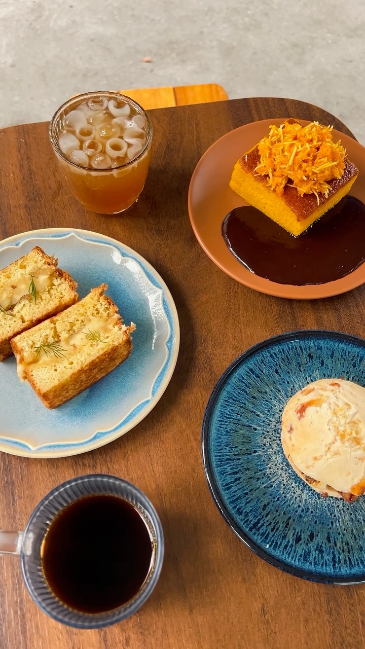 Mesa com fatias de bolo, café coado e bebida gelada